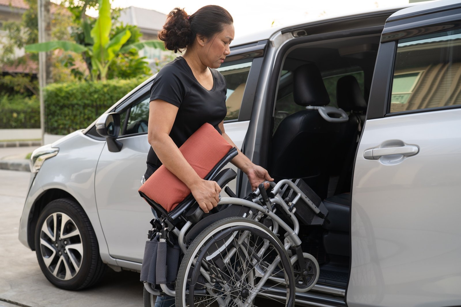 Asian disability woman on wheelchair getting in her car, Accessibility concept.
