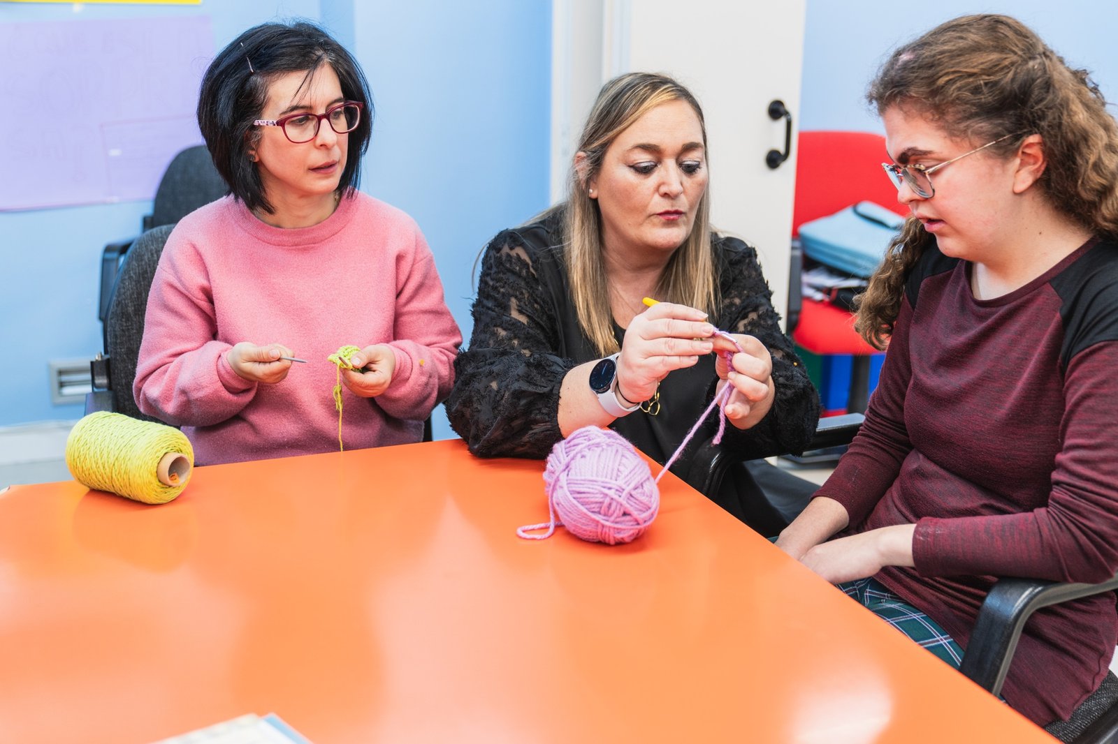 Teacher Instructing Disabled Students in a Sewing Workshop